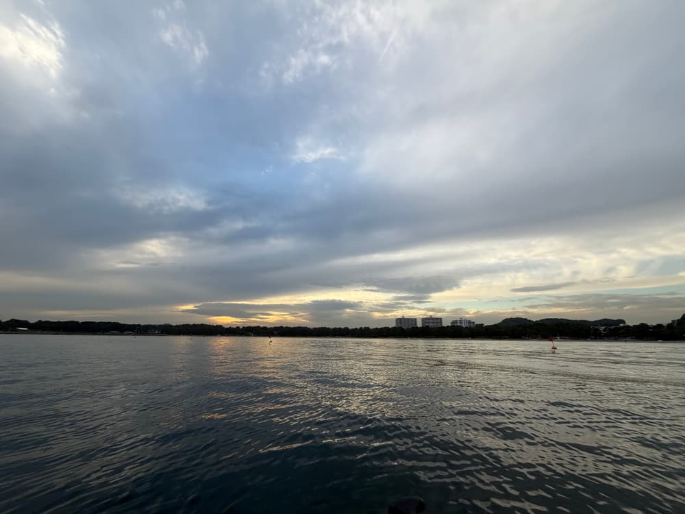 雲の切れ間から光が差す海の公園の湾